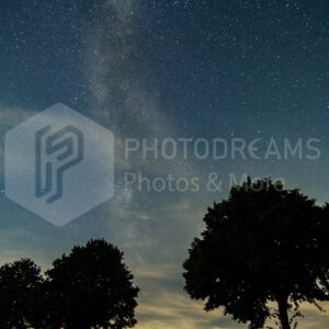 Milky Way with trees and wind wheels in Germany